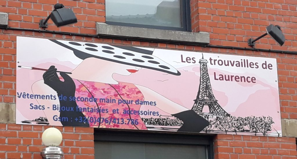Bâche publicitaire imprimée Les trouvailles de Laurence fixée sur une façade en brique