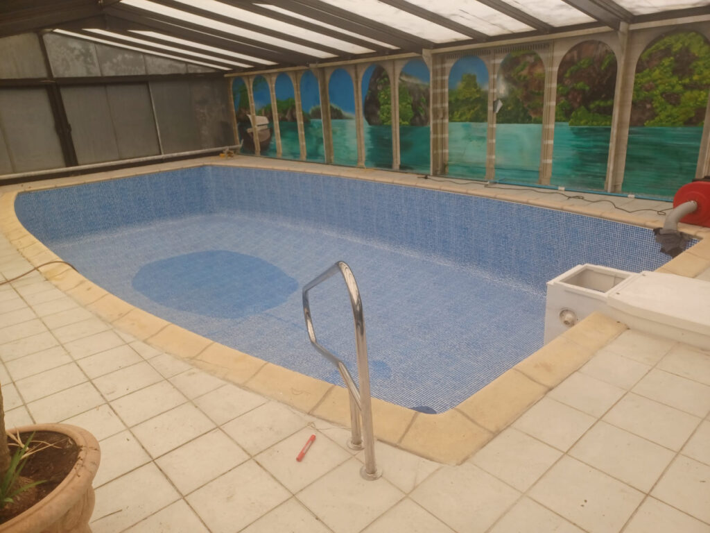 Piscine intérieure sous véranda équipée d'un liner bleu clair